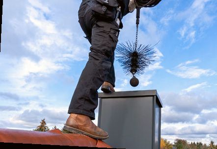 Technician atop a chase cover with a weighted flue brush